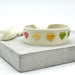 KI-generiertes Bild,Canvas Statement Armband Herzen Multi Colour Bunt Quasten besticktes Webarmband